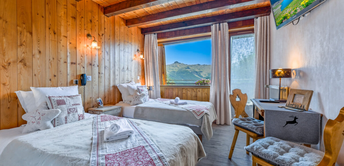 Chambre Twins Confort avec deux lits jumeaux, poutres apparentes et vue sur les montagnes