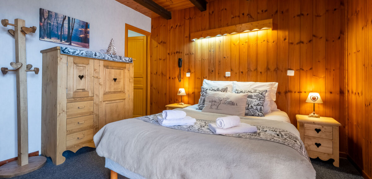 Lit double avec dessus-de-lit en fausse fourrure et armoire en bois sculpté de cœurs