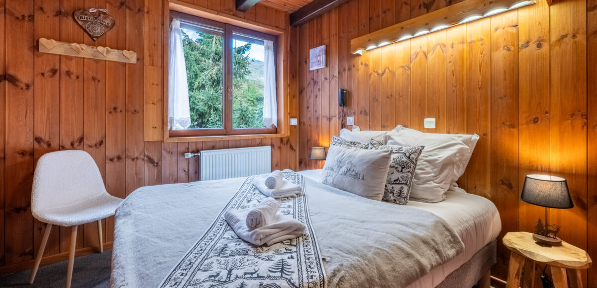 Lit double avec plaid brodé de cerfs et tête de lit en bois éclairée