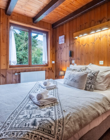 Lit double avec plaid brodé de cerfs et tête de lit en bois éclairée