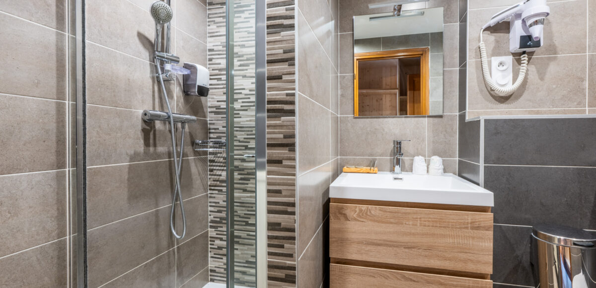 Salle de bain avec douche à l'italienne, vasque en bois clair et carrelage gris anthracite