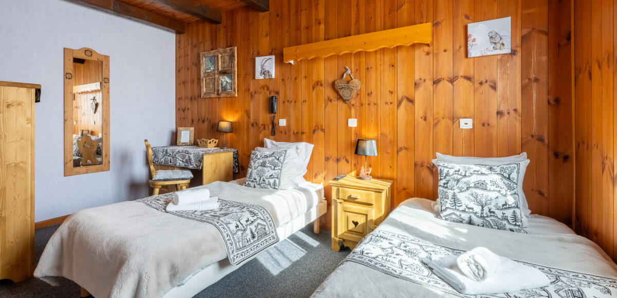 Chambre twins avec deux lits jumeaux, miroir et bureau en bois